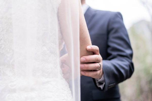 A groom gently holding his bride's arm
